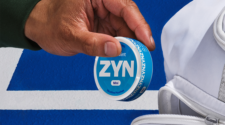 Mano con lata de pouches de nicotina abierta